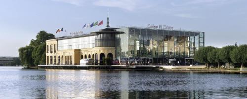 a large building next to a body of water at L'oasis d'Enghien-les-bains in Enghien-les-Bains