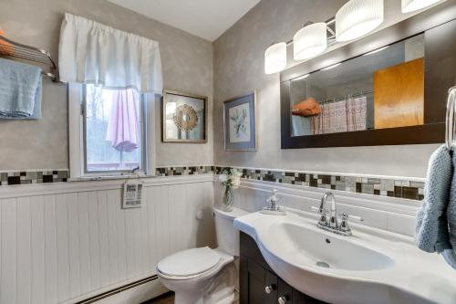 een badkamer met een wastafel, een toilet en een spiegel bij Rector Home with Hot Tub about 6 Mi to Ligonier! in Rector