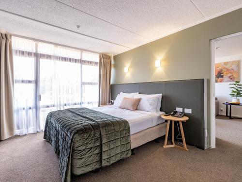 a hotel room with a bed and a window at Auckland Rose Park Hotel in Auckland