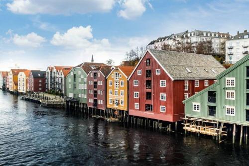 a row of colorful buildings next to a river at Hidden gem near the Old Town Bridge, 40m² apt. in Trondheim