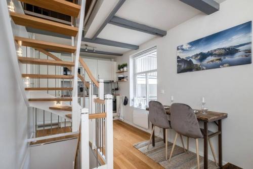 a room with a staircase and a table and chairs at Hidden gem near the Old Town Bridge, 40m² apt. in Trondheim
