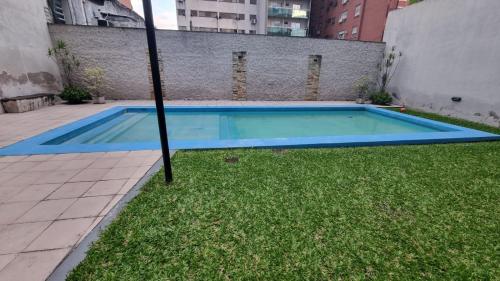 an empty swimming pool in a yard with grass at Nord Suite - Departamento Premium en Barrio Norte in San Miguel de Tucumán