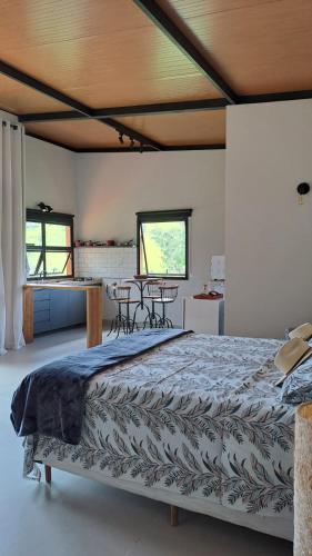 a large bed in a room with two tables at Chalés do Mato Dentro in Paraisópolis