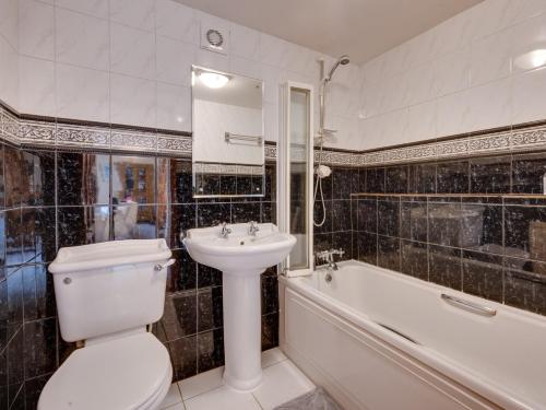 a bathroom with a toilet and a sink and a tub at 1 Bed in Glossop 52417 in Glossop