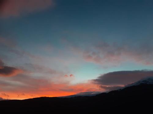 a sunset in the sky with mountains in the background at Villë Dallëndyshe 