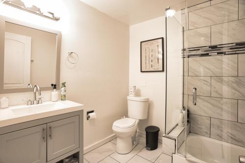 y baño con aseo, lavabo y ducha. en McCormick HUGE 3Br with Pool table, Optional Parking for up to 8 guests, en Chicago