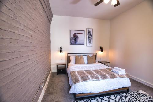 1 dormitorio con cama y pared de ladrillo en McCormick HUGE 3Br with Pool table, Optional Parking for up to 8 guests, en Chicago