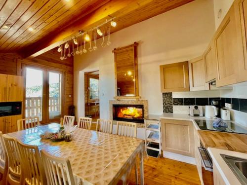 a kitchen and dining room with a table and a fireplace at Méribel Chalet Merveilleux in Les Allues