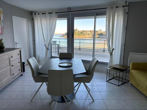 une salle à manger avec une table et une chambre avec vue dans l'établissement Appartement le Cristal Dinard bord de mer, à Dinard