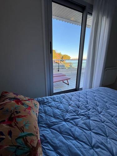 une chambre avec un lit et une porte coulissante en verre dans l'établissement Appartement le Cristal Dinard bord de mer, à Dinard