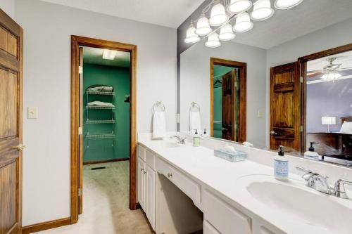 baño con 2 lavabos y espejo grande en Spacious Derby Home with Hot Tub, en Louisville