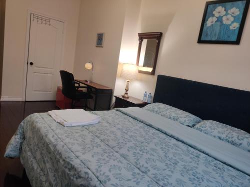 a bedroom with a bed with a blue comforter at Super Huge Comfortable King Bedroom near Toronto Pearson Airport in Mississauga
