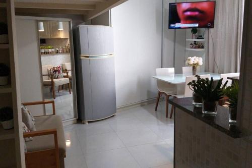 a kitchen and dining room with a refrigerator and a tv at Lindo Ap-Centro de Guarapari(Sem Compartilhamento) in Guarapari