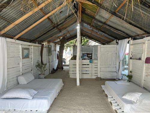 a bedroom with two beds and a roof at Punta Arena EcoHostal Coco in Playa Punta Arena
