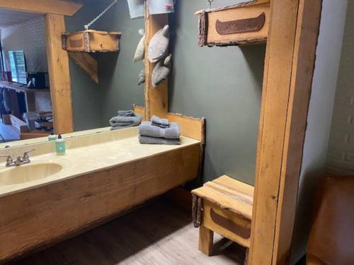 La salle de bains est pourvue d'un lavabo et d'un miroir. dans l'établissement Stonegate Lodge King Bed, WIFI, 50in Roku TV, Salt Water Pool Room #107, à Eureka Springs