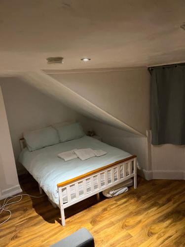 um pequeno quarto com uma cama no sótão em Largs Top Floor Flat em Largs