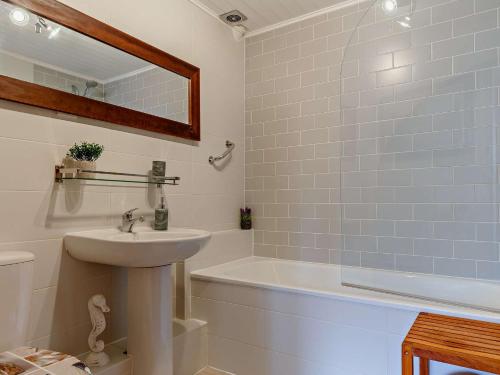 a white bathroom with a sink and a bath tub at 2 Bed in Brixham BX083 in Brixham
