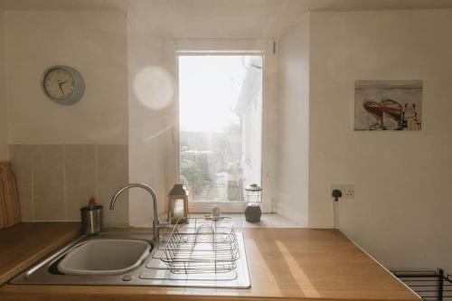 a kitchen with a sink and a window at SUMMER VIEW - Escape to our Cosy Cottage with Log Burner in Drigg