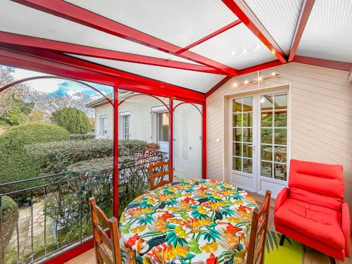 une véranda avec une table et des chaises dans l'établissement Jardin Secret - Maison Proche de l'Hippodrome, à Orléans