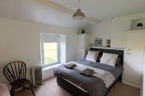 Un dormitorio con una cama grande y una ventana en SUMMER VIEW - Escape to our Cosy Cottage with Log Burner en Drigg