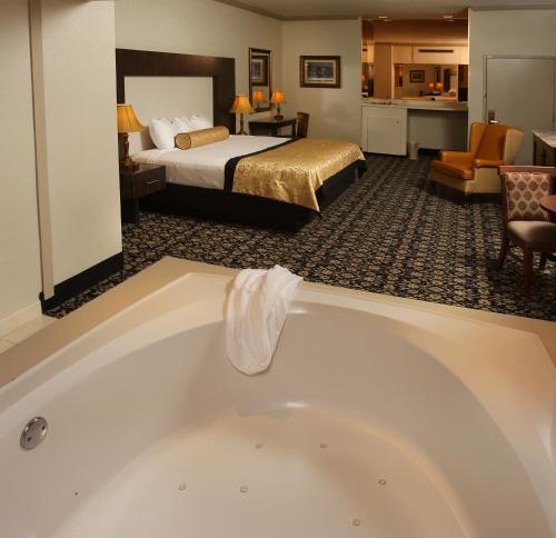 um quarto de hotel com uma banheira e uma cama em The Claridge Hotel em Atlantic City
