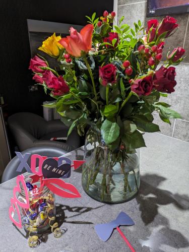 a vase filled with flowers on a table with some bows at Hotel 33 in Blackpool