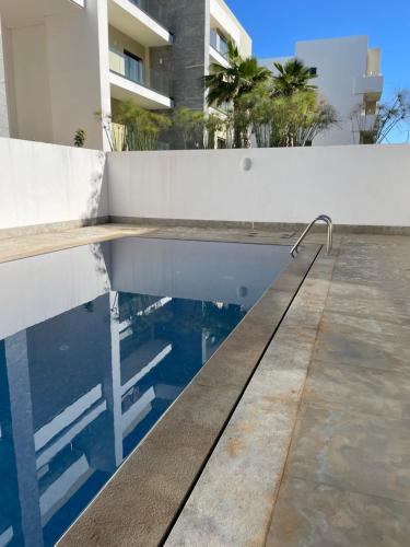 une piscine en face d'un bâtiment dans l'établissement Haut standing apartement secured residence, 