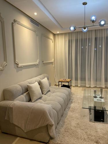 a living room with a couch and a table at Haut standing apartement secured residence in Oulad Mbark