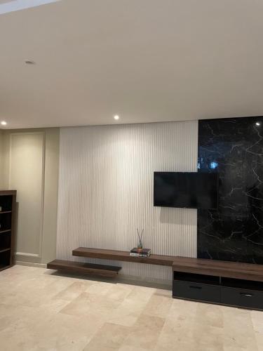 a living room with a television on a wall at Haut standing apartement secured residence in Oulad Mbark