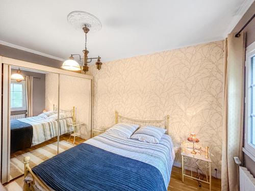 une chambre avec deux lits et une fresque murale dans l'établissement Jardin Secret - Maison Proche de l'Hippodrome, à Orléans