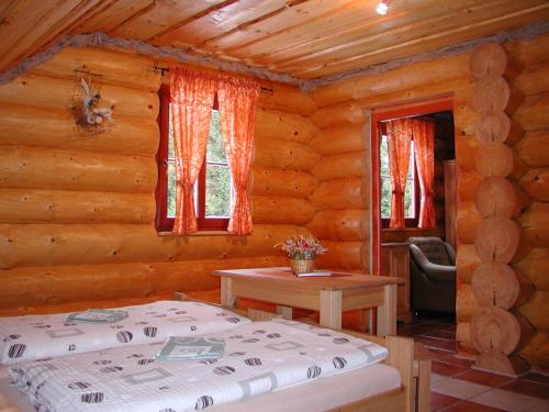 sypialnia z łóżkiem w drewnianym domku w obiekcie Chata - Srub Kašparáci w Jańskich Łaźniach