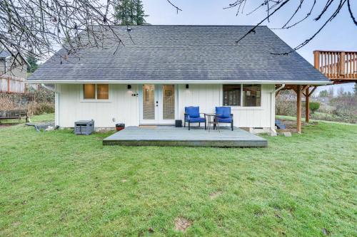 a white house with two blue chairs on a porch at Stylish Bellingham Home with Lake and Mountain Views! in Bellingham