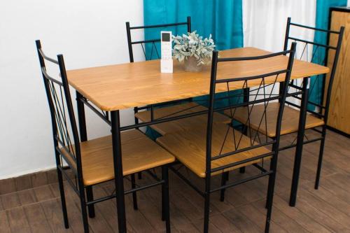 a wooden table with four chairs and a table with a vase at Salamanca Loft in Los Güichiches