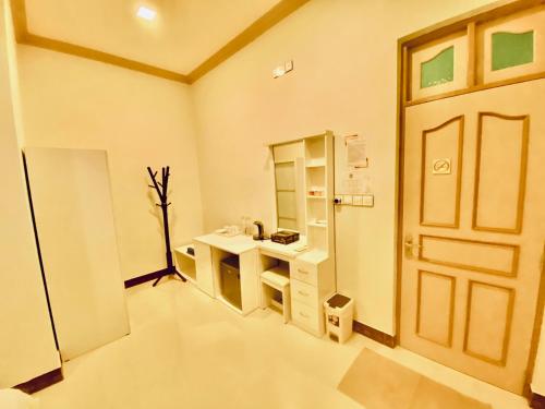 Oasis Village Fenfushi, Maldives في Fenfushi: حمام فيه باب ومغسلة ومرآة