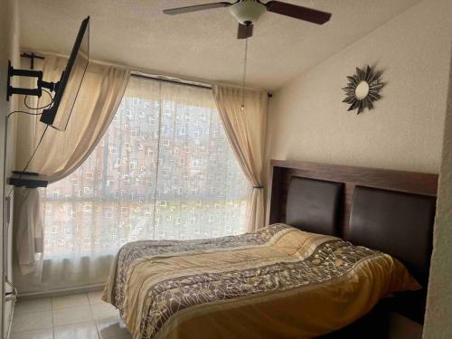 Schlafzimmer mit einem Bett, einem Deckenventilator und einem Fenster in der Unterkunft El Ducado de Yauteland in Yautepec de Zaragoza