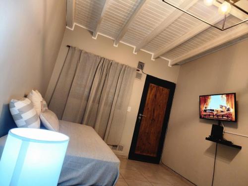 een slaapkamer met een bed en een tv aan de muur bij Departamento ciudad de Mendoza calle Rondeau in Barraquero