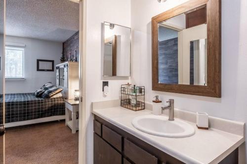 baño con lavabo, espejo y cama en Cozy Cabin-Style Condo in Central Location en Mammoth Lakes