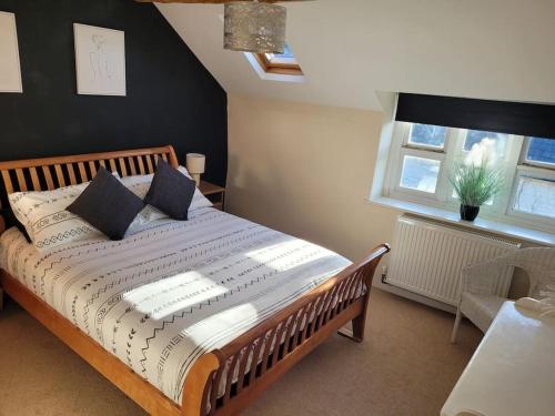 a bedroom with a large bed with pillows on it at Cosy modern cottage by the sea, heart of snowdonia in Llwyngwril