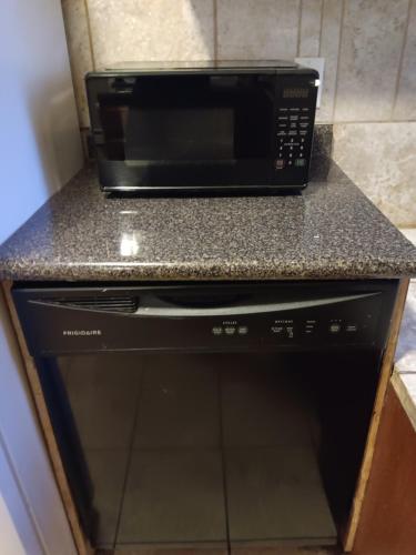 a black microwave oven sitting on top of a counter at The Top-Floor at Centerdale Village Room B* Private Room in North Providence
