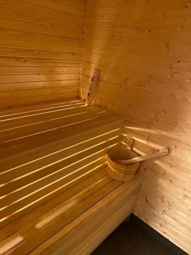 una pequeña sauna de madera con un cubo dentro en Newly built apartment with large terrace in the middle of the hill, en Duved