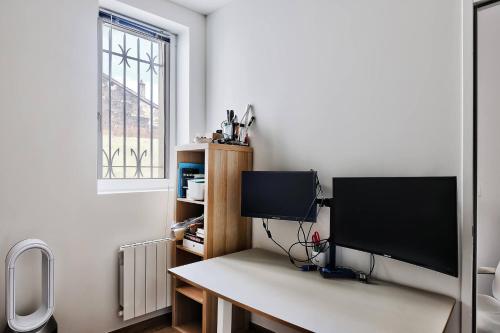 un monitor de ordenador sentado en un escritorio en una habitación en Somptueux saint-genois en Saint-Genis-Laval