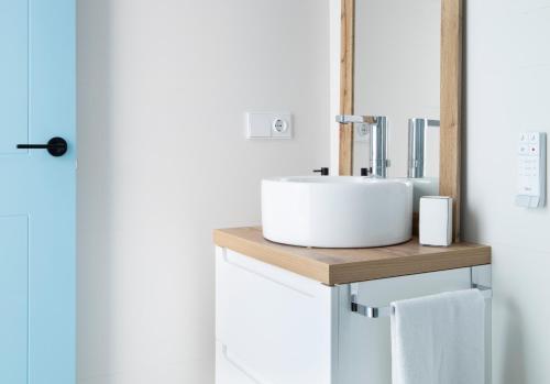 ein Badezimmer mit einem weißen Waschbecken auf einer Holztheke in der Unterkunft Apartamento Nc Beach Home 31-B in Bellreguart