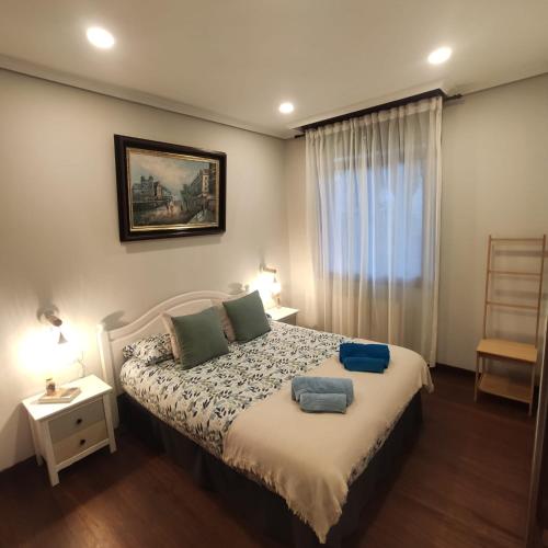 a bedroom with a bed with two pillows and a window at Casa Charo Prexigueiro in Ribadavia