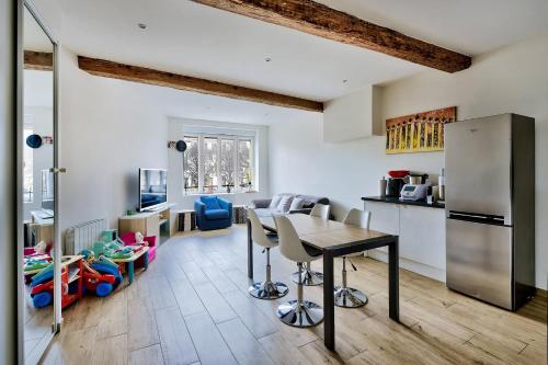 a kitchen and living room with a table and chairs at Somptueux saint-genois in Saint-Genis-Laval