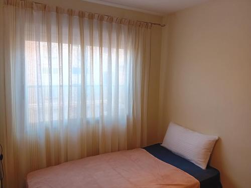 1 dormitorio con cama y ventana en Canet Holiday, en Valencia