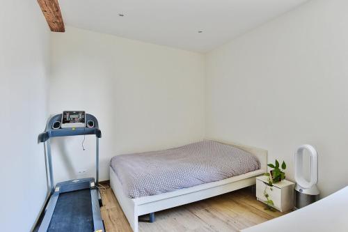 a small bedroom with a bed and a treadmill at Somptueux saint-genois in Saint-Genis-Laval