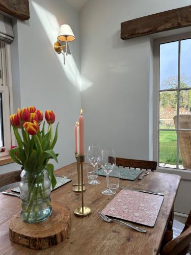 a wooden table with a candle and flowers in a vase at Favour Royal Cottage - dog friendly forest escape in Derrygorry