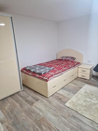 a bedroom with a bed with a red comforter at small apartment for two in Brus