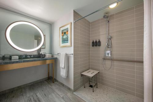 a bathroom with a shower and a sink and a mirror at Hotel Dena, Pasadena Los Angeles, a Tribute Portfolio Hotel in Pasadena