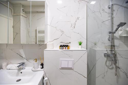 baño blanco con ducha y lavamanos en Penthouse Apartman Roko, en Virovitica